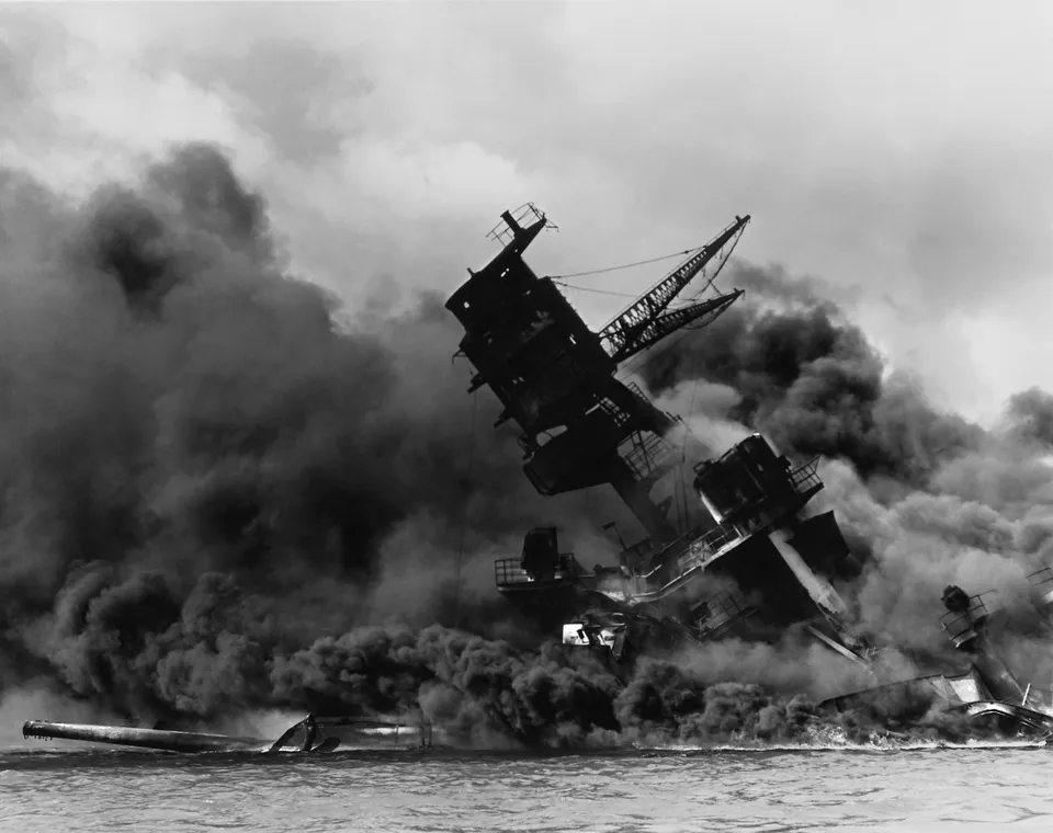 The battleship USS Arizona burning and sunk after the Japanese attack, Pearl Harbor, 7 December 1941