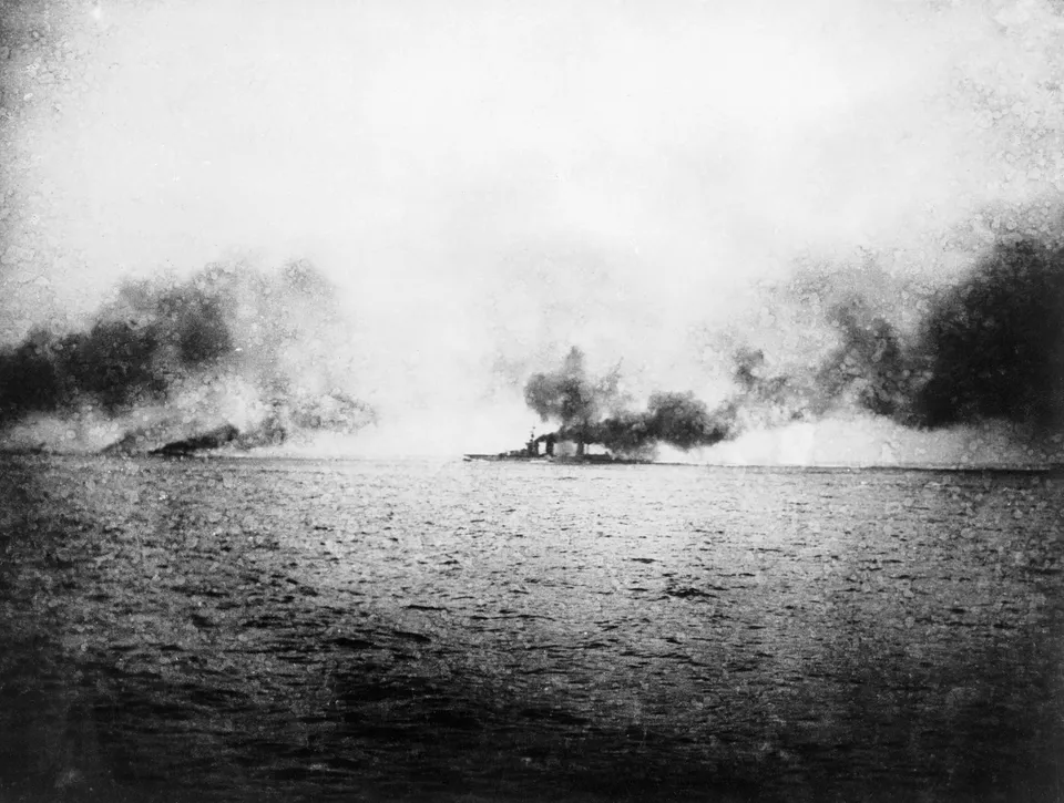 The British battlecruiser HMS Lion (on the horizon) after a hit on her “Q” turret from a German battlecruiser — Jutland, 31 May 1916