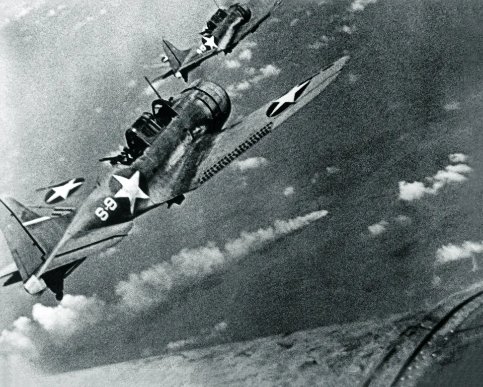 US SBD Dauntless dive-bombers approach the burning Japanese heavy cruiser Mikuma, 6 June 1942