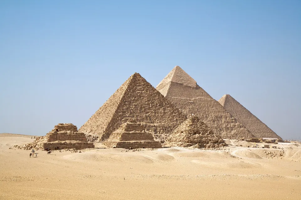 The three pyramids of Giza from the desert to the south-west: in front, the pyramid of Menkaure with three small queens’ pyramids; in the middle, Khafre’s, with casing stones left at the top; at the back right, the Great Pyramid of Khufu