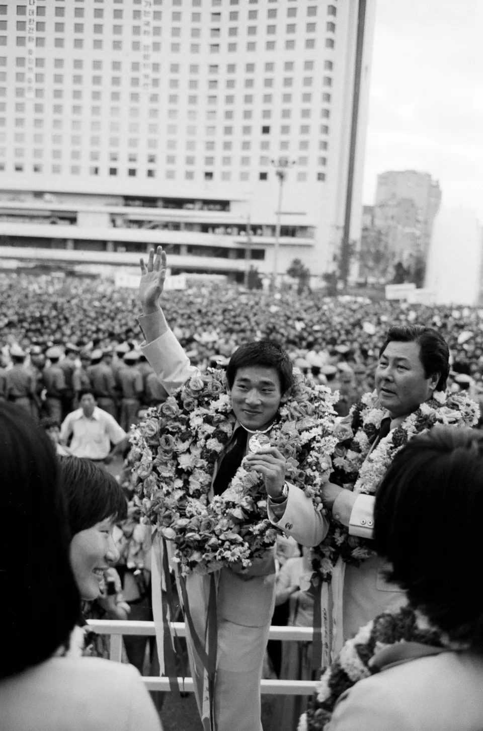 Wrestling gold medallist Yang Jung-mo (centre) at the welcome rally for the Korean team back from Montreal, Seoul, 3 August 1976