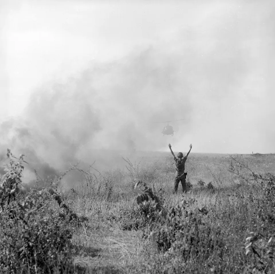 부상병을 실으러 내려오는 UH-1 휴이 헬리콥터를 유도하는 미군 — 1966년 10월, 남베트남
