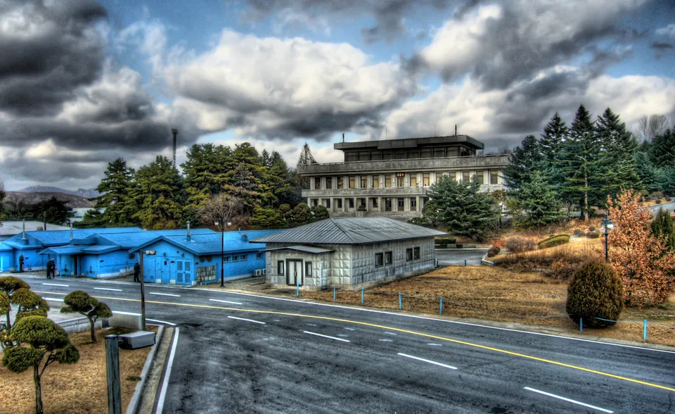 군사 분계선 위에 걸쳐 선 판문점의 파란 회담장 건물들 — 남북 군인이 마주 선 공동 경비 구역, 2008년